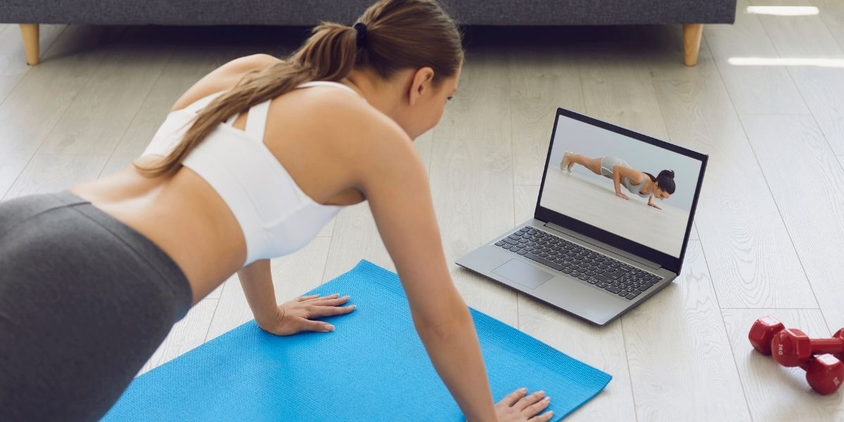 40代女性が自宅でYouTube動画を見ながら筋トレをしている様子