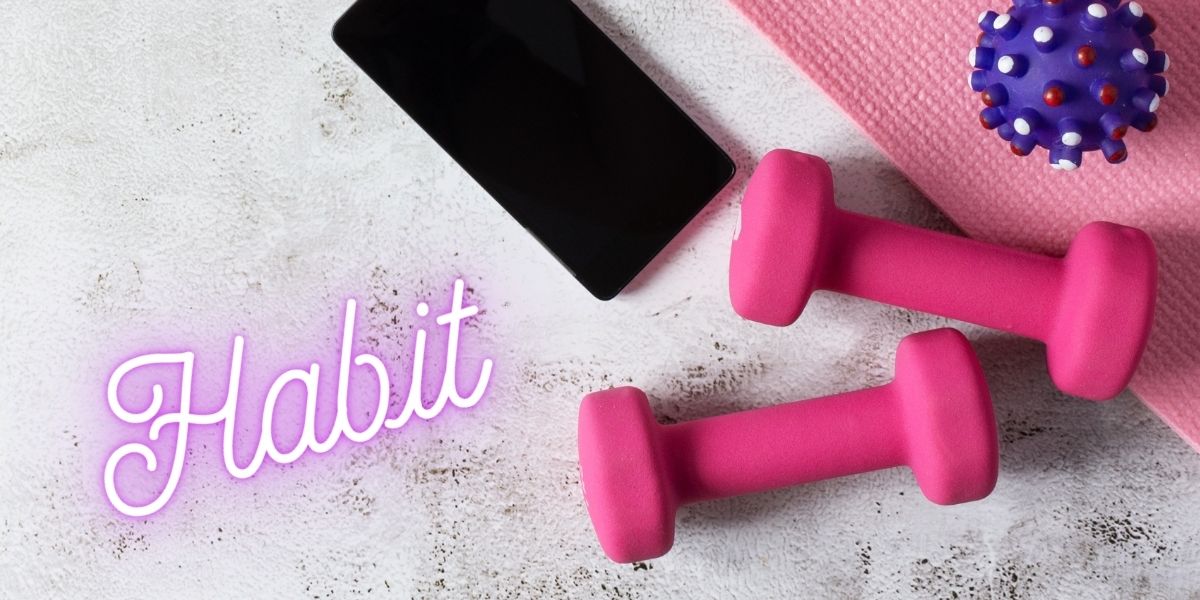 習慣（Habit）」の文字とともに、ピンクのダンベル、スマートフォン、ヨガマットが並ぶ筋トレ習慣化のイメージ写真。アプリや動画を活用して運動を習慣化するヒントを伝える画像