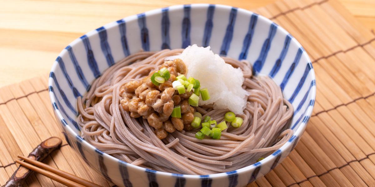 ボディメイク中におすすめの十割蕎麦アレンジ。納豆と大根おろしをトッピングした十割蕎麦で、筋トレ中のダイエットをサポートする食事例。