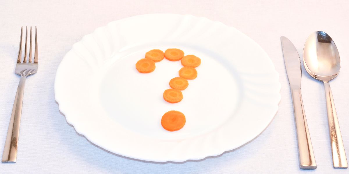 皿の中央にニンジンの「?」、横にカトラリー。置き換えや事前ルールで迷いを減らすイメージ(40〜50代向け)