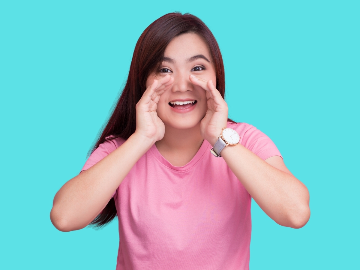 本音を叫ぶように口に手を当てる女性のイメージ