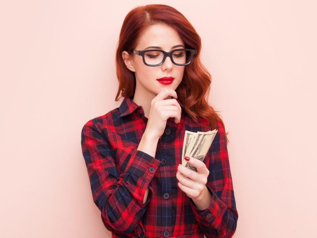お札を見ながら料金について考える女性のイメージ